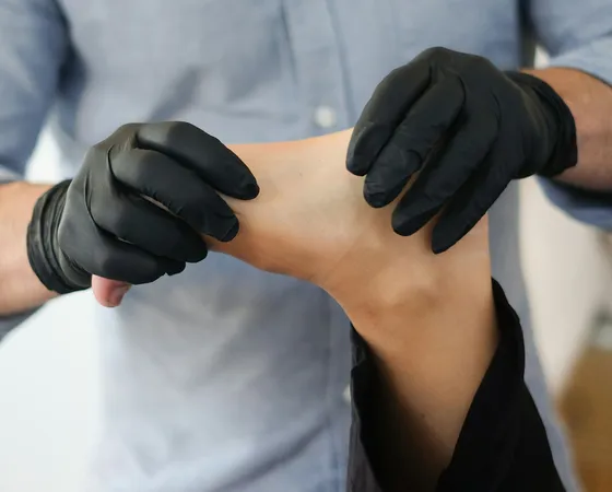 Podiatrist examining a patient's foot and ankle during a home visit